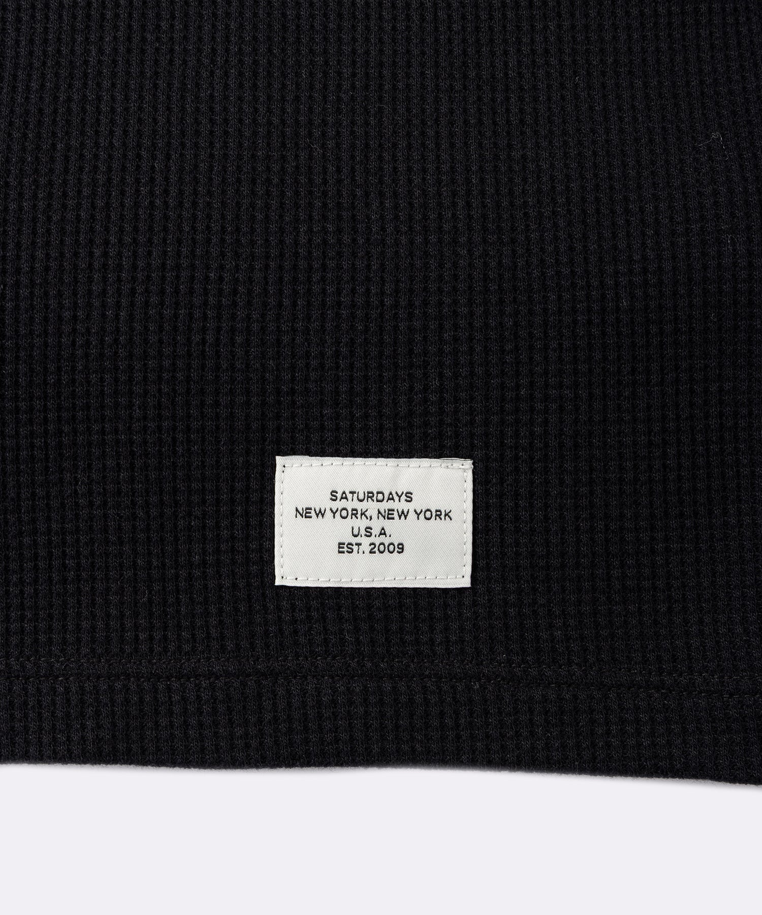 Hanes x Saturdays NYC Waffle Long Sleeve Tee in Black, close-up of Saturdays NYC hem label
